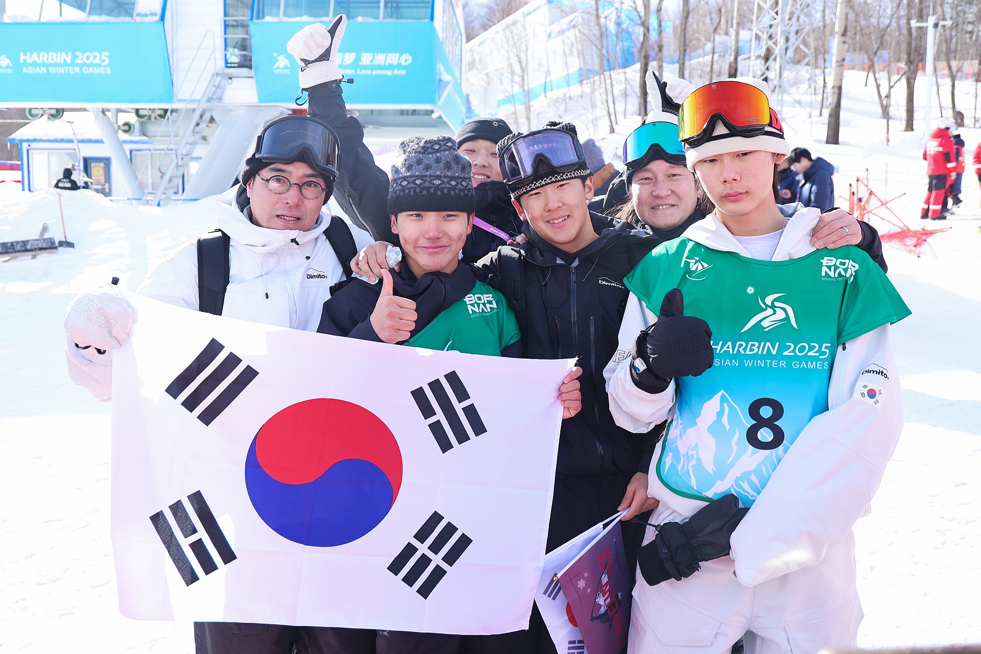 Gold medalist Kim Geonhui (second from left in front row) and bronze medalist Lee Jio (fourth from left in front row) on Feb. 13 pose for a photo with other members of the national team at the men's snowboarding halfpipe finals of the Asian Winter Games at Yabuli Ski Resort in Shangzi, southeast of Harbin, China. (Yonhap News)  