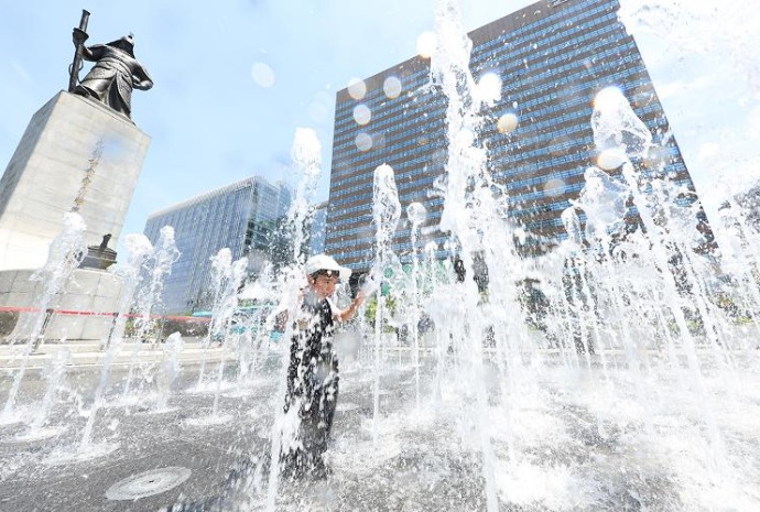Summer fun in water next to statue of legendary admiral
