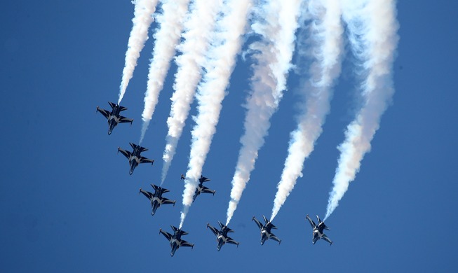 Acrobatic air show decorates blue sky