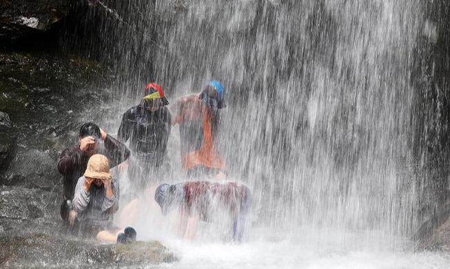 Cooling off at waterfall amid heat wave