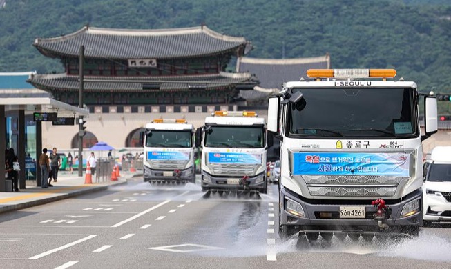 Street sweeper trucks spray downtown road