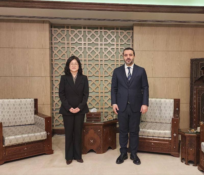 Kim Eunjeong (left), director-general of the African and Middle Eastern Affairs Bureau of the Ministry of Foreign Affairs, on Feb. 7 poses for photos with Assad al-Shaibani, interim minister of foreign affairs and expatriates of the Syrian transitional government, in Damascus, Syria. (Ministry of Foreign Affairs)  